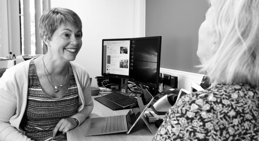 Jane talking with a client across the desk at the Age Less clinic in Plymouth